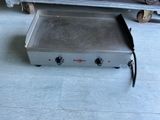 une petite plaque de cuisson électrique posée au sol dans une pièce