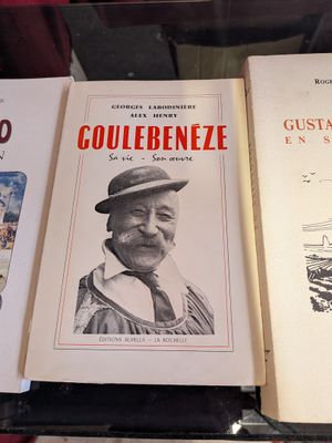 Trois livres sont exposés dans une vitrine posée sur une table
