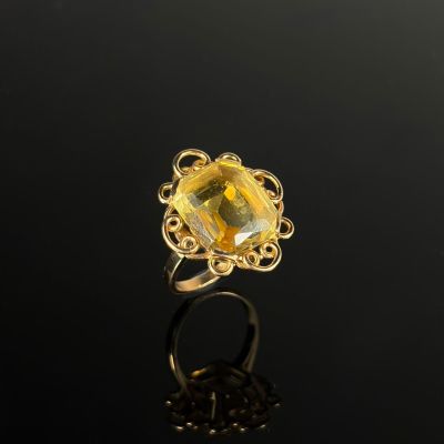 une bague en or sertie d'une citrine de taille ovale, entourée de motifs en filigrane
