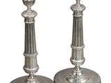 une paire de bougeoirs en argent sur fond blanc, avec un fond blanc