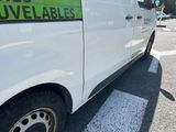 a white van parked in a parking lot with a green sign on the side of the van
