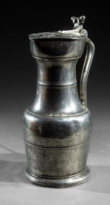an image of a silver vase with a handle on a table