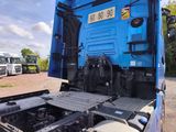 a blue truck that is parked in a lot