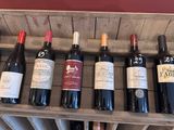bottles of wine are lined up on a wooden rack in a wine cellar