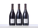 three bottles of wine sitting on top of a white table