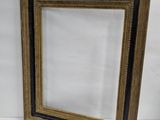 a black and gold picture frame with a white background