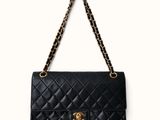 un sac Chanel noir auquel est suspendue une chaîne dorée
