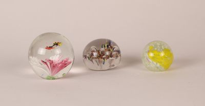 three glass marbles sitting on top of a table next to each other