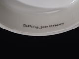a white bowl with writing on it sitting on a table
