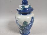 un vase bleu et blanc avec un couvercle sur une table
