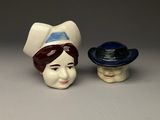 deux figurines en céramique représentant des femmes coiffées de chapeaux
