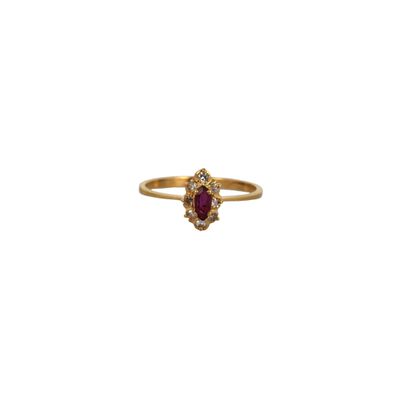 a gold ring with an oval ruby stone surrounded by small white diamonds