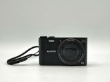 the camera is sitting on a white surface with a cord attached to it