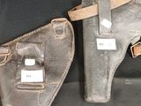deux paires d'étuis en cuir posés sur une surface noire