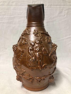 un vase brun posé sur une table à fond blanc