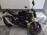 une photo d'une moto noire garée sur un sol à damier