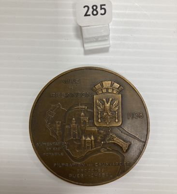 un gros plan d'une médaille posée sur une surface blanche, avec une étiquette de prix