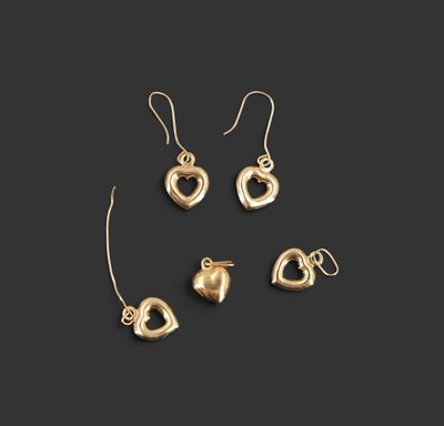 un ensemble composé de trois boucles d'oreilles en forme de cœur dorées et d'une paire de boucles d'oreilles