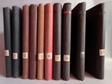 several old books are lined up in a row on a white surface