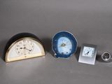 two clocks and a small clock sitting on a table