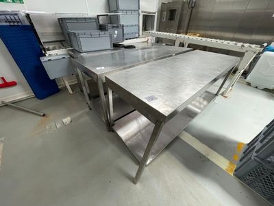 une grande table en acier inoxydable au milieu d'une cuisine