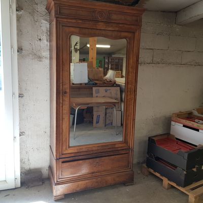 une grande armoire en bois surmontée d'un miroir
