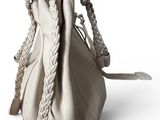 beige leather handbag with braided handles on a white background