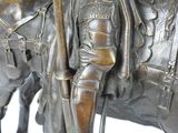 bronze statue of a man on a horse with a staff