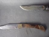 two knives that are laying next to each other on a table