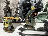 two figurines of soldiers on display in front of a picture