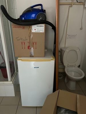 une boîte posée sur un petit réfrigérateur dans une salle de bains