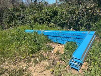 un morceau de métal bleu qui traîne dans l'herbe