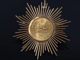 a close up of a gold medal on a black surface