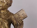 statue of a boy holding a book and a book in his hand