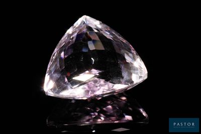 gros plan d'un diamant rose sur une surface noire