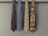 three different colored ties hanging on a clothes rack in a room