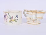 pair of porcelain cups and saucers with floral designs on them