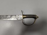 a close up of a sword on a white surface
