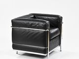 black leather recliner with chrome legs and arm rests against a white background