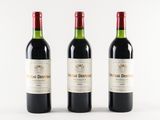three bottles of red wine sitting next to each other on a white surface