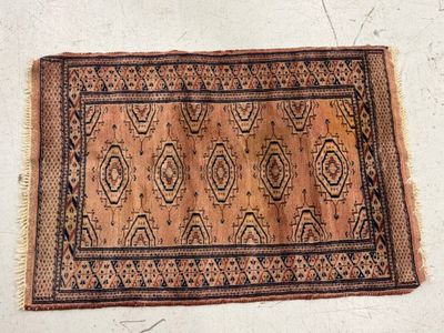 a close up of an old rug on a white surface
