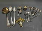 a lot of silver spoons and spoons on the table