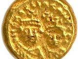 une pièce d'or sur une surface blanche avec un fond blanc