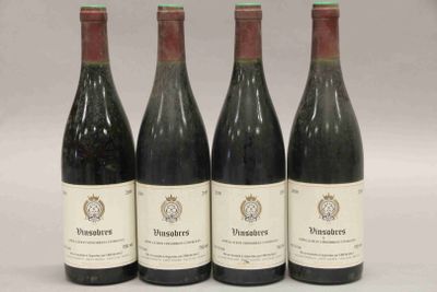 quatre bouteilles de vin sont alignées sur une surface blanche