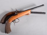 an old gun with a wooden handle on a white surface