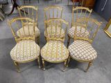 four antique chairs with upholstered seats in a room with a mirror on the wall