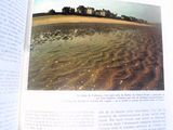 un livre ouvert sur lequel figurent une plage et une maison
