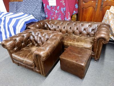 un canapé et un pouf en cuir marron dans une pièce