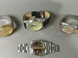 three watches and a wrist watch are sitting on a table