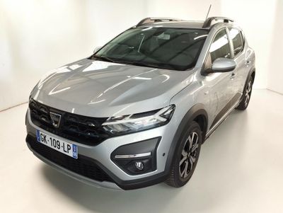 Un SUV argenté est garé dans une pièce blanche